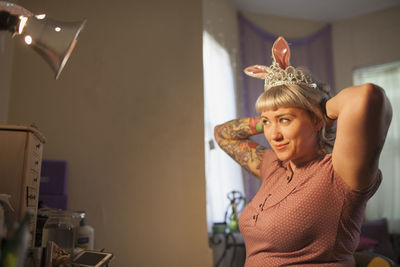 Young woman in front of mirror wearing bunny ears