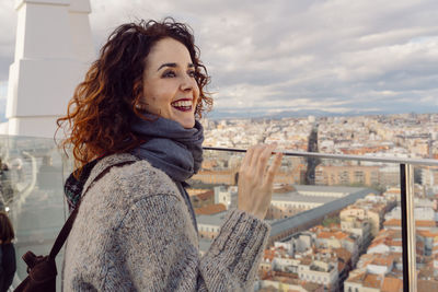 Smiling woman standing against cityscape