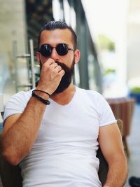 Portrait of young man wearing sunglasses standing outdoors