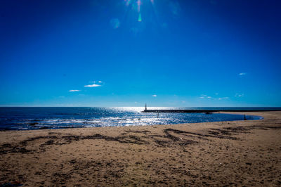 Scenic view of beach against blue sky