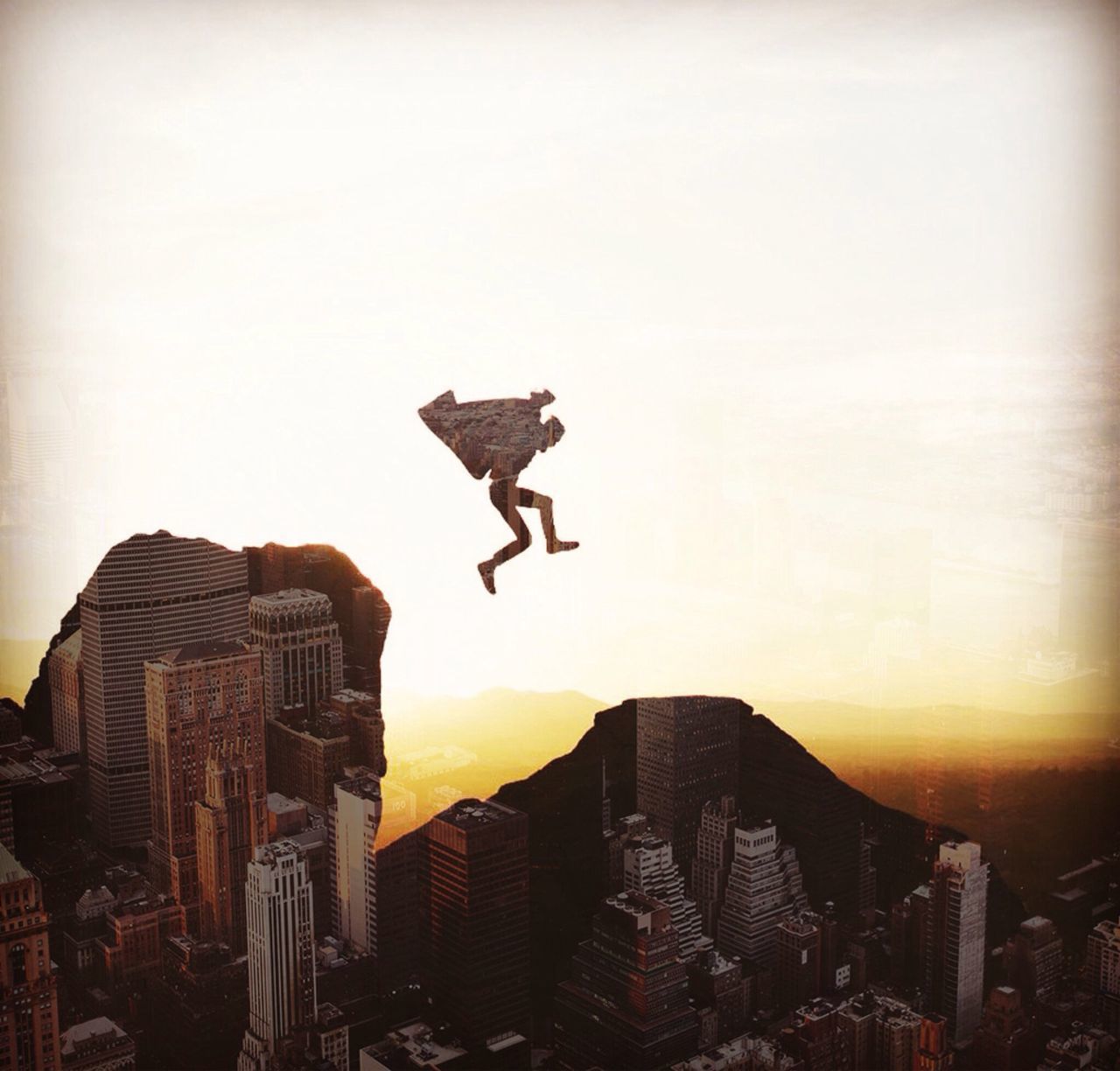 SILHOUETTE OF MAN JUMPING OVER SKYSCRAPER