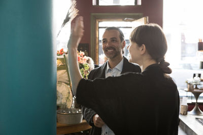 Smiling mature male customer and female entrepreneur talking at store