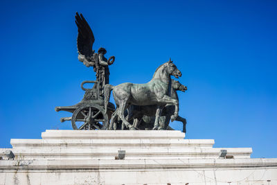 Low angle view of statue against blue sky