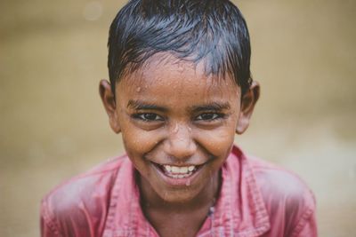 High angle portrait of smiling wet boy enjoying in rainy season