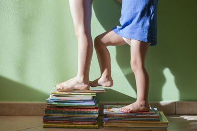 Low section of children standing on stacked books