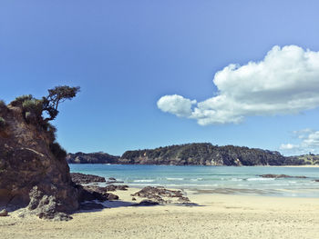 View of calm beach against blue sky