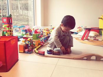 Cute boy playing with toys at home