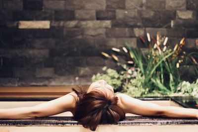 Woman lying in hot spring outdoors