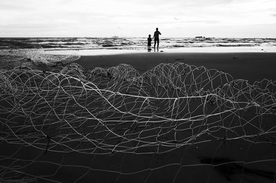 Silhouette man on beach against sky