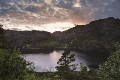 Scenic view of lake by mountains against sky