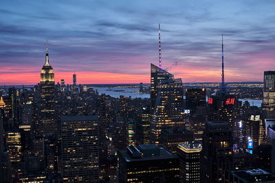 Illuminated buildings in city during sunset