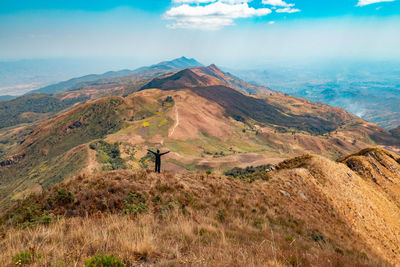 Rear view of a hiker in the panoramic mountain landscapes at mbeya peak in mbeya region, tanzania