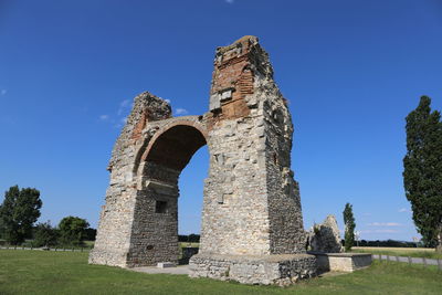 Low angle view of old ruins against clear blue sky