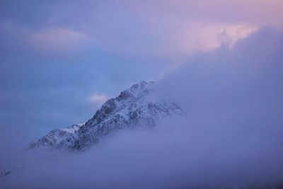 Majestic blue mountain peaking behind winter clouds