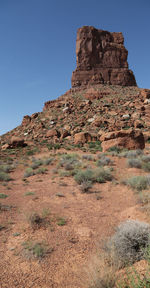 Low angle view of rock formations against clear blue sky