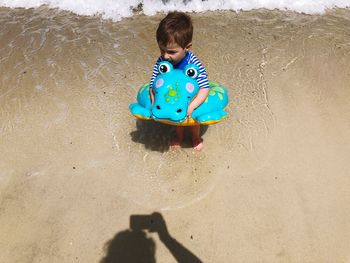 High angle view of boy with toy on beach