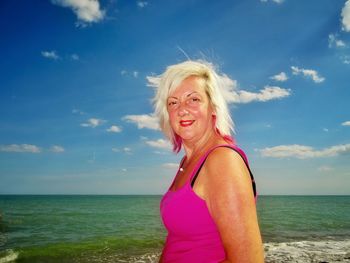 Portrait of mature woman standing at beach