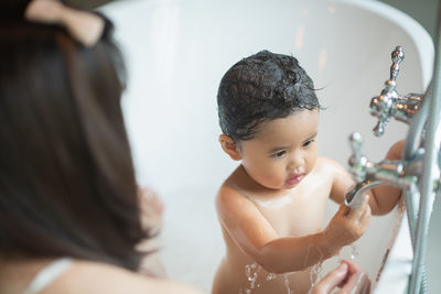 Cute girl sitting in bathtub