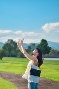 Rear view of woman standing on field against sky