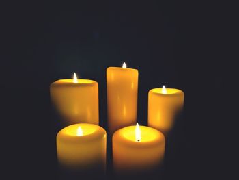 Close-up of lit candle in dark room