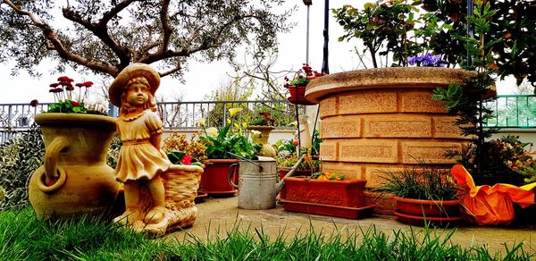 Statue in front of potted plants