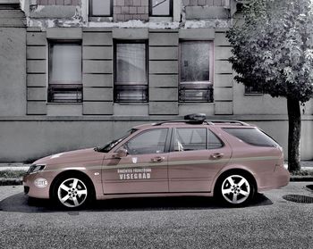 Car on road by buildings in city