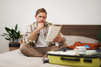 Young woman using mobile phone while sitting at home