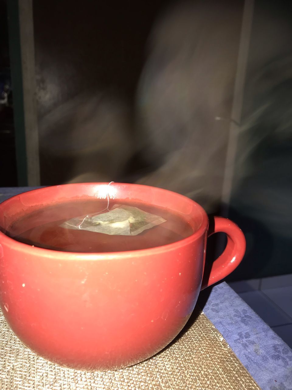 CLOSE-UP OF RED TEA CUP ON TABLE