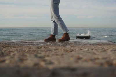 Low section of person standing on beach