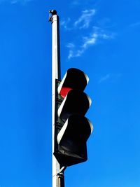 Low angle view of stoplight against blue sky