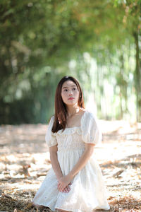 Portrait of woman sitting in park looking away