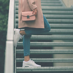 Low section of woman standing on staircase