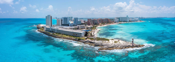 Panoramic view of sea by city against sky