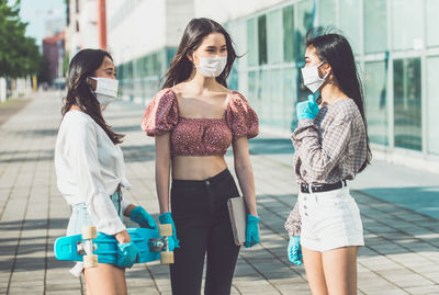 Young woman standing against people in city