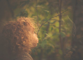 Close-up of girl blowing spider web