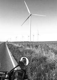 Wind turbines on field against clear sky