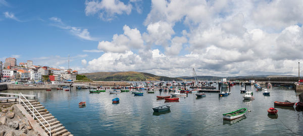 Sailboats moored in sea against sky