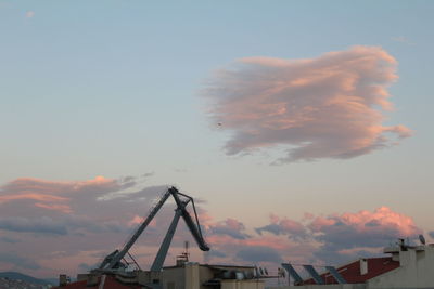 Low angle view of crane against sky at sunset