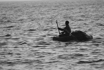 Man rowing boat in sea