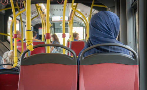 Rear view of people sitting in train