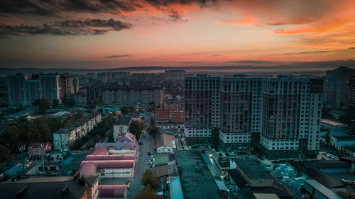 High angle view of modern buildings against sky during sunset