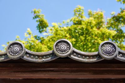 Close-up of ceramic roof tiles against blue sky