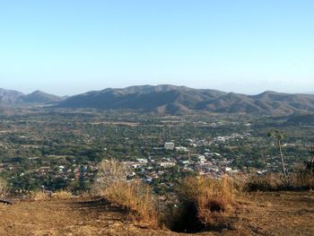 Aerial view of landscape and mountains against clear blue sky