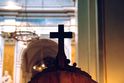 Low angle view of cross on building against sky