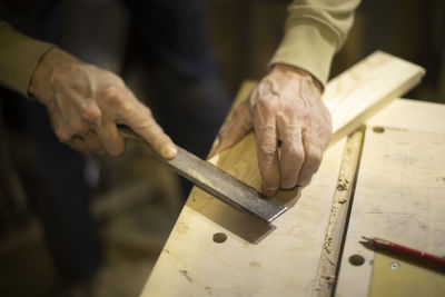 Carpenter cuts tree. stripping corner. creating furniture from board. details of work.