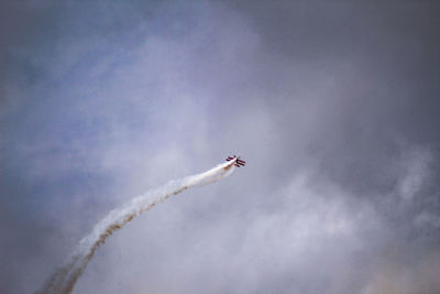 Low angle view of airplane flying against sky during airshow