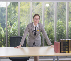 Portrait of young man using laptop at office