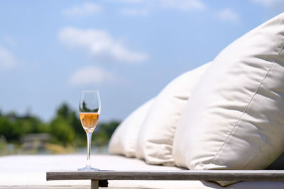 Close-up of champagne on furniture outdoors against sky