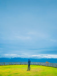 Young man photographer working with tripod on the top of the hill , freedom and recreation concept