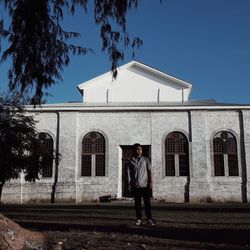Full length of man standing by building against sky